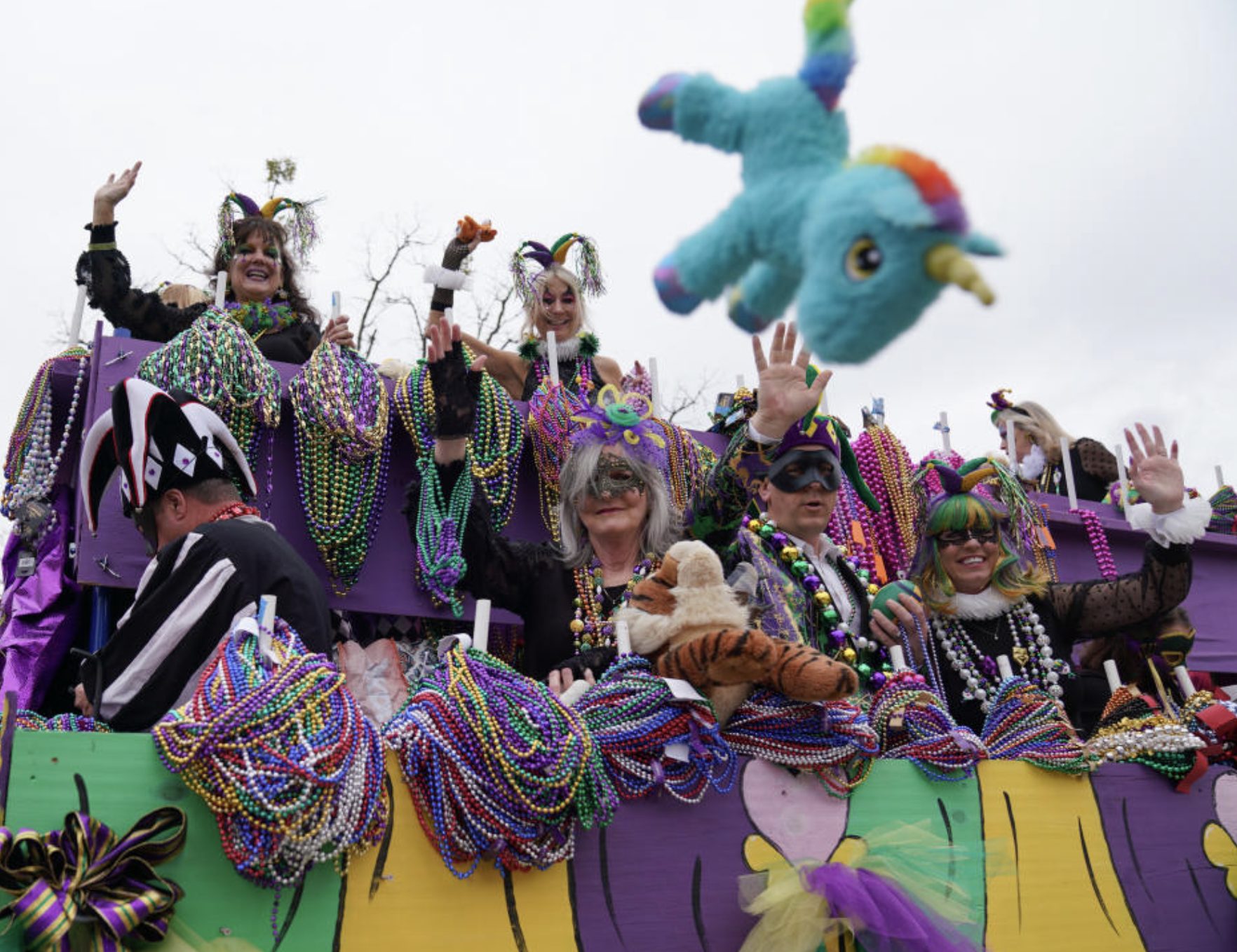Mardi Gras parade in Auburn and Opelika featuring costumed riders, colorful beads, and festive floats